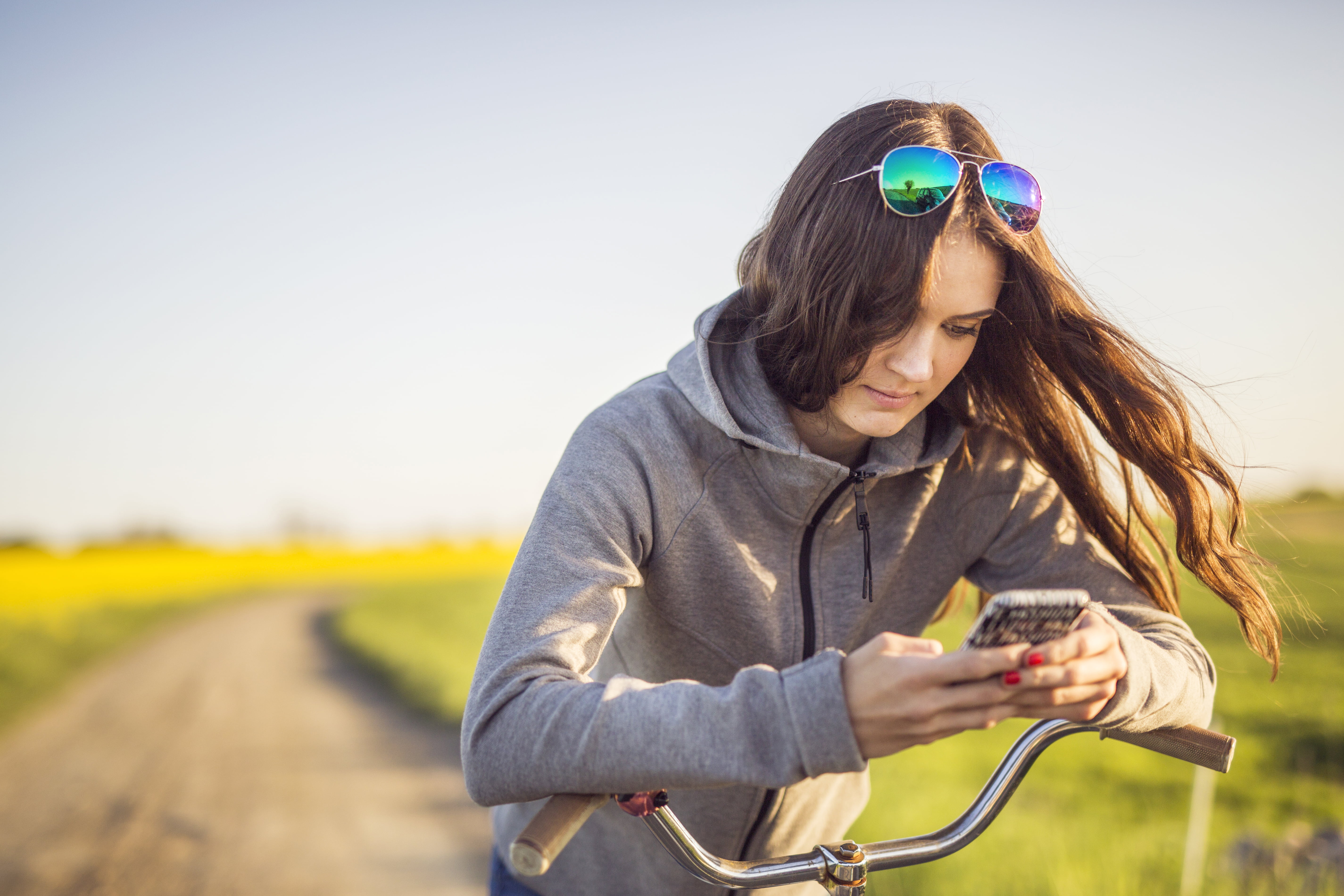 jente med sykkel og mobiltelefon